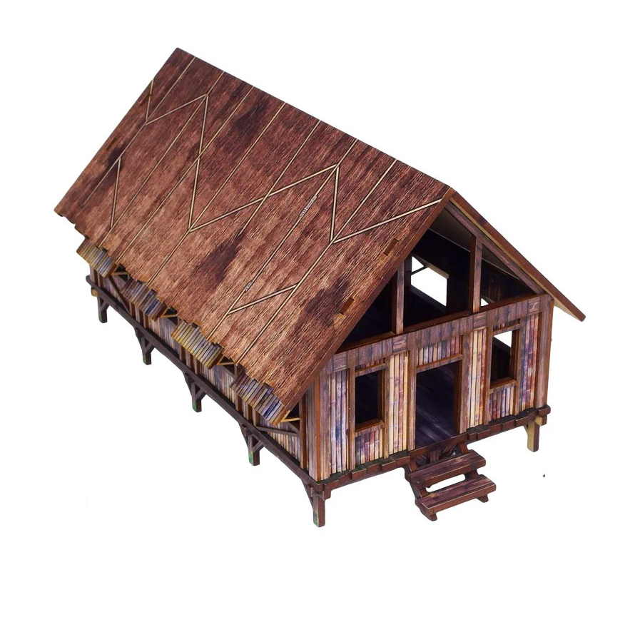Wooden model cabin with a detailed roof on a white background. WW2 Pacific barracks pre painted jungle building 28mm scale terrain for Bolt Action wargaming tables