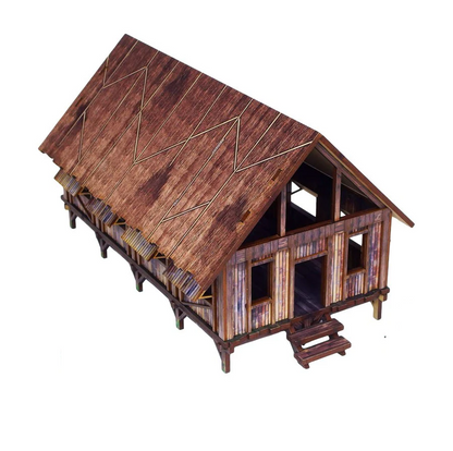 Wooden model cabin with a detailed roof on a white background. WW2 Pacific barracks pre painted jungle building 28mm scale terrain for Bolt Action wargaming tables