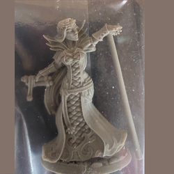 Reaper miniatures. This elegant sorceress is dressed in a long gown with dramatic collar, holding a scroll in one hand and the other outstretched in front of her.  