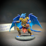  dragonfolk rouge holding a dagger in one hand and a pouch in the other. Mrs MLG has painted this miniature with a blue palette adding white dot effects to the wings, the armour is golden colour and Tazythas has a red loin cloth.