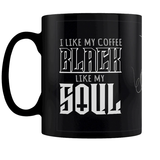 A black mug featuring a flourish design and writing saying I Like My Coffee Black Like My Soul in white