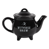 ceramic black cauldron shaped tea pot has the words Witches Brew in white on the side