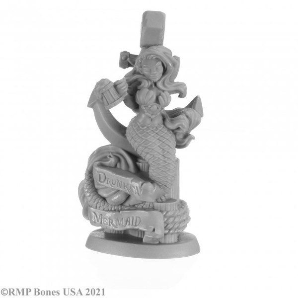 Reaper Miniatures bones USA gaming figure. This mermaid is sat on an anchor on a wooden post with one hand behind her head in her hair and the other holding a tankard of ale, her tail wraps around a sign saying 'Drunken Mermaid'.
