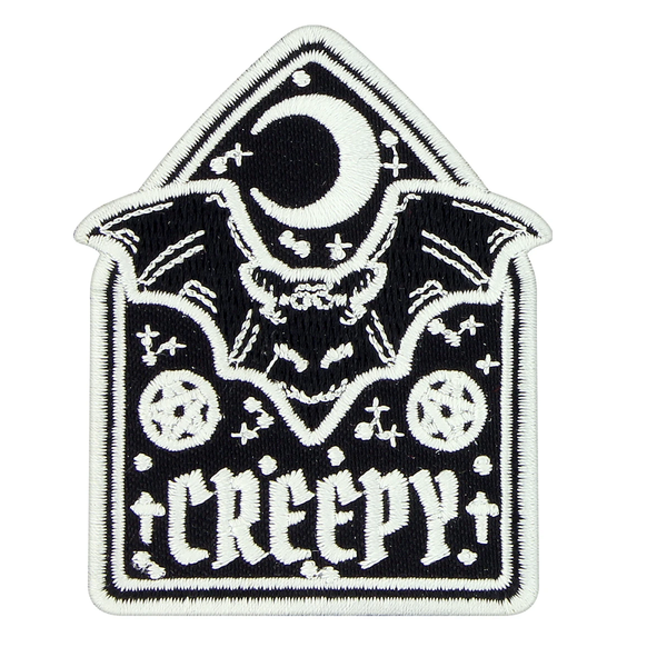 A monochromatic iron on patch featuring a crescent moon above a bat with two pentagrams and the word Creepy at the bottom