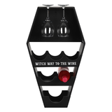 coffin shaped wine shelf is black with the words Witch Way To The Wine in white. 2 glasses and one bottle of wine 