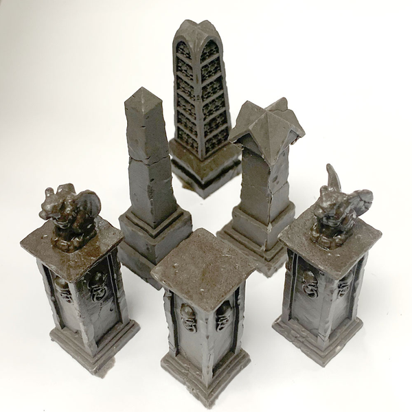 Graveyard Pillar Set by Legend Games is a set of six pillars which combines some of the other pillar sets from the range together in one set. Two pillars are topped with a grotesque in the classic winged demon style one having a broken wing and one pillar is adorned with skulls