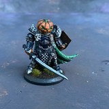 A Reaper Miniature Halloween Knight hand painted by Mrs MLG, a fierce pumpkin headed warrior wearing armour, holding a sword in one hand and a coffin lid shield in the other with a green cape flapping behind. 