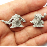 Ugruk-tar Goblin Mercenaries by Spellcrow. A pack of 2 resin miniatures and 2 bases (25mmx25mm) depicting Goblins, one wearing a mask, fur shawl and a dagger behind his back and the other holding the dagger out to the side and his bottom exposed.