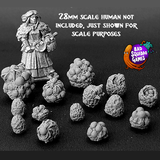 A pack of fourteen resin spiders eggs in various sizes including some with spiders by Bad Squiddo Games. shown with human figure for scale