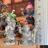 Toil And Trouble by Northumbrian Tin Solider is a set of 3 miniatures, two witches and a cauldron. One witch has a walking stick and pointed hat, one holds a broom and a mushroom and the cauldron contains the spell being cooked up and a frog attempting to escape. 