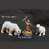 an unpainted bear, a painted human figure holding an axe above her head and an unpainted miniature of a capybara for scale reference 
