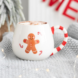 rounded white mug featuring a red and white stripe handle and a gingerbread 