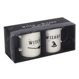 Boxed set two white mugs and black handles, one mug has a picture of a broomstick and the word Witch the other has a picture of a hat and says wizard. The box is black