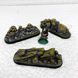 A set of three rock outcrops by Legend Games, shown with a miniature for scale