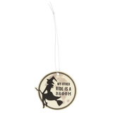 A hanging rose scented air freshener in a circle shape representing the moon with a witch riding a broomstick design and the words 'My Other Ride Is A Broom'