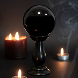 beautiful black crystal ball and stand with candles 