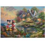 Disney Mickey & Minnie Sweetheart Cove1000 Piece Jigsaw Puzzle. A beautiful image by Thomas Kinkade of Micky & Minnie Mouse sharing a kiss on the cheek with sweetheart cove river and cottage in the background making a wonderful valentines gift or for a Disney collector. 