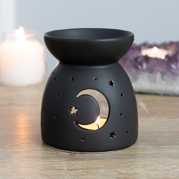 A matt black oil burner with a cut out crescent moon and star design