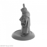 Brother Hammond from the Dark Heaven Legends metal range by Reaper Miniatures sculpted by Bobby Jackson. Holding a wooden staff in one hand and a book tucked under his other arm Brother Hammond has the hood of his robe up and walks barefoot