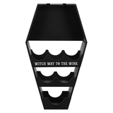 coffin shaped wine shelf is black with the words Witch Way To The Wine in white