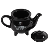 ceramic black cauldron shaped tea pot has the words Witches Brew in white on the side and the lid removed and placed on the floor