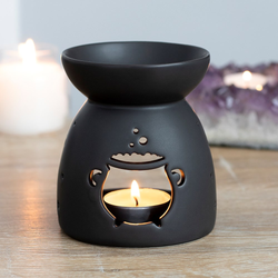 A matt black oil burner with a cut out bubbling cauldron design 