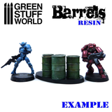A set of resin oil barrels by Green Stuff World with miniatures for size