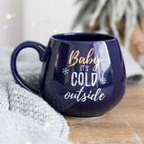 A beautiful rich blue rounded mug with gold and white writing saying 'Baby It's Cold Outside'.