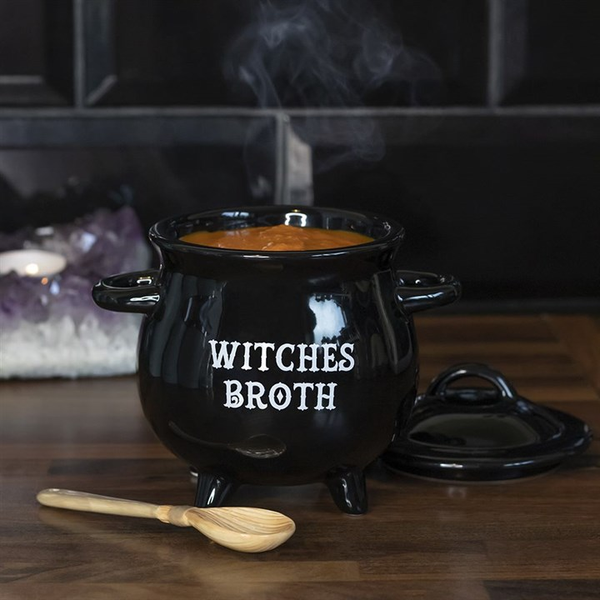 witches broth cauldron shaped soup bowl with a spoon designed to look like a witches broom, lid and spoon to each side and bowl full or soup