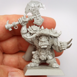 Kar'Ku by spellcrow. . This resin miniature of an Orc holds a Axe above his head and clawed weapons strapped to his other hand. With a chain around his neck, fur copped cape at his back and Orc snarl on his face. shown held in a hand
