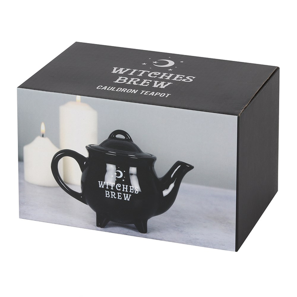 boxed ceramic black cauldron shaped tea pot has the words Witches Brew in white on the side