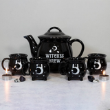black teapot has white writing 'Witches Brew' and a white crescent moon and stars, the black cups feature white luna crescent moon and star design.
