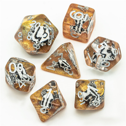 RPG dice set, clear with white numbers and a black and white desert bull skull shape on a bed of gold glitter representing the sand.