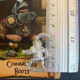 Commander Boots by Northumbrian Tin Solider is an old school style metal miniature for your gaming table holding a club in one hand and pointing with the other, shown with a ruler