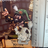 The Great Melvyn by Northumbrian Tin Solider a dwarf wizard that carries a owl staff, wears wealthy clothing and jewels as well as money bags at his hip, shown here with a ruler