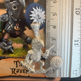 The Raven by Northumbrian Tin Solider a metal miniature for your gaming table holding a mace in one hand, a round shield in the other, a beaked shaped helmet and large feather adornment., shown here with a ruler
