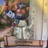 The Spellcaster by Northumbrian Tin Solider holds a stick up high with his other hand keeping the frog from escaping from his bag, shown here with a ruler 
